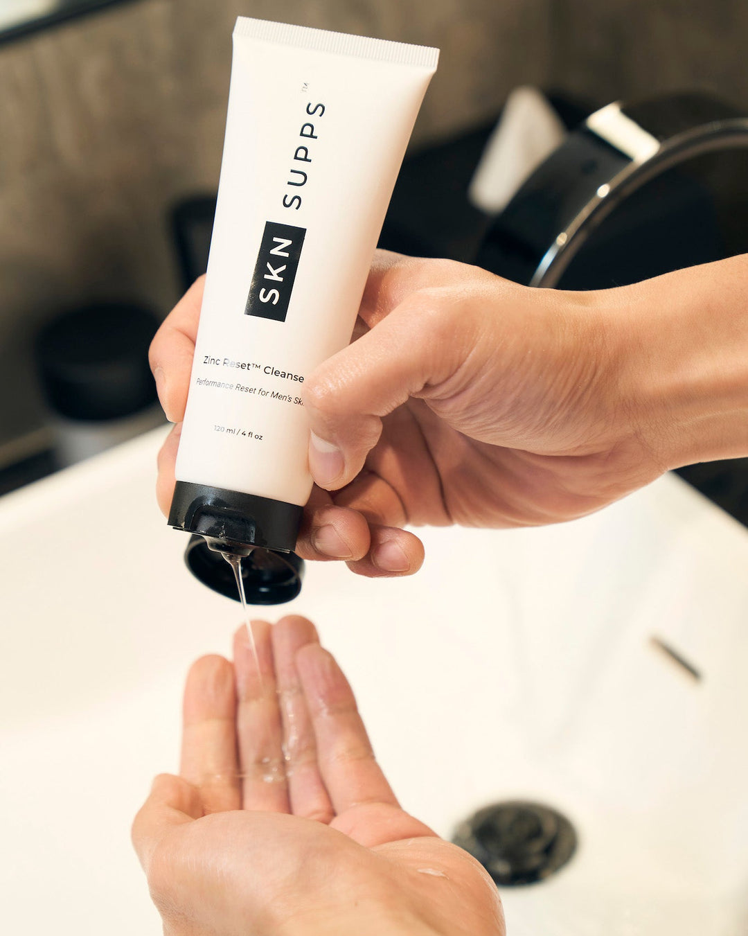 Man holding SKN SUPPS Zinc Reset daily face wash in bathroom.